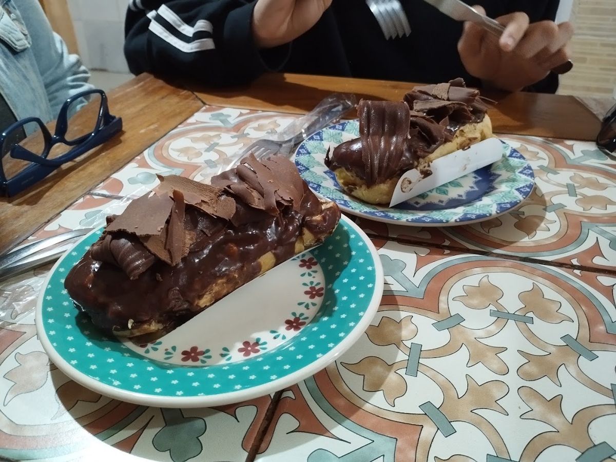 Fatia de bolo de chocolate com lascas de chocolate em prato de bolinhas