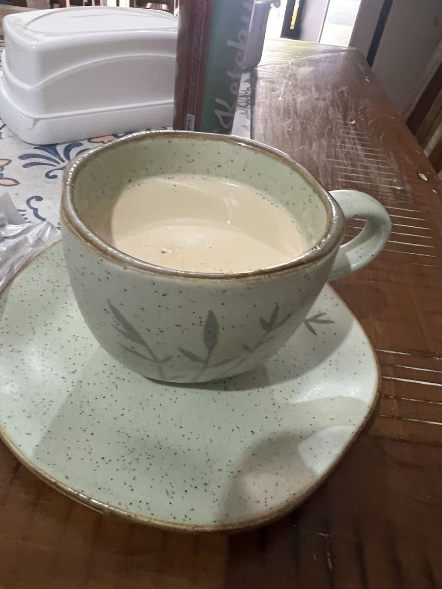 Xícara de café com leite na mesa de madeira