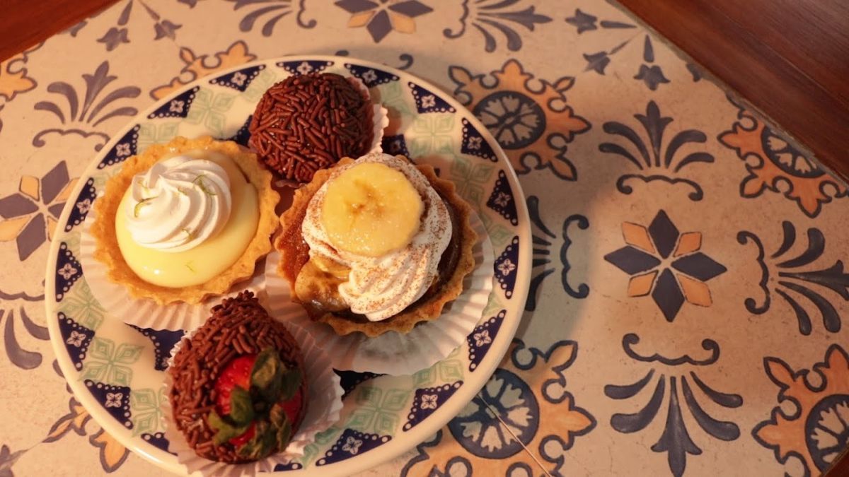 Prato com docinhos variados sobre mesa de ladrilho